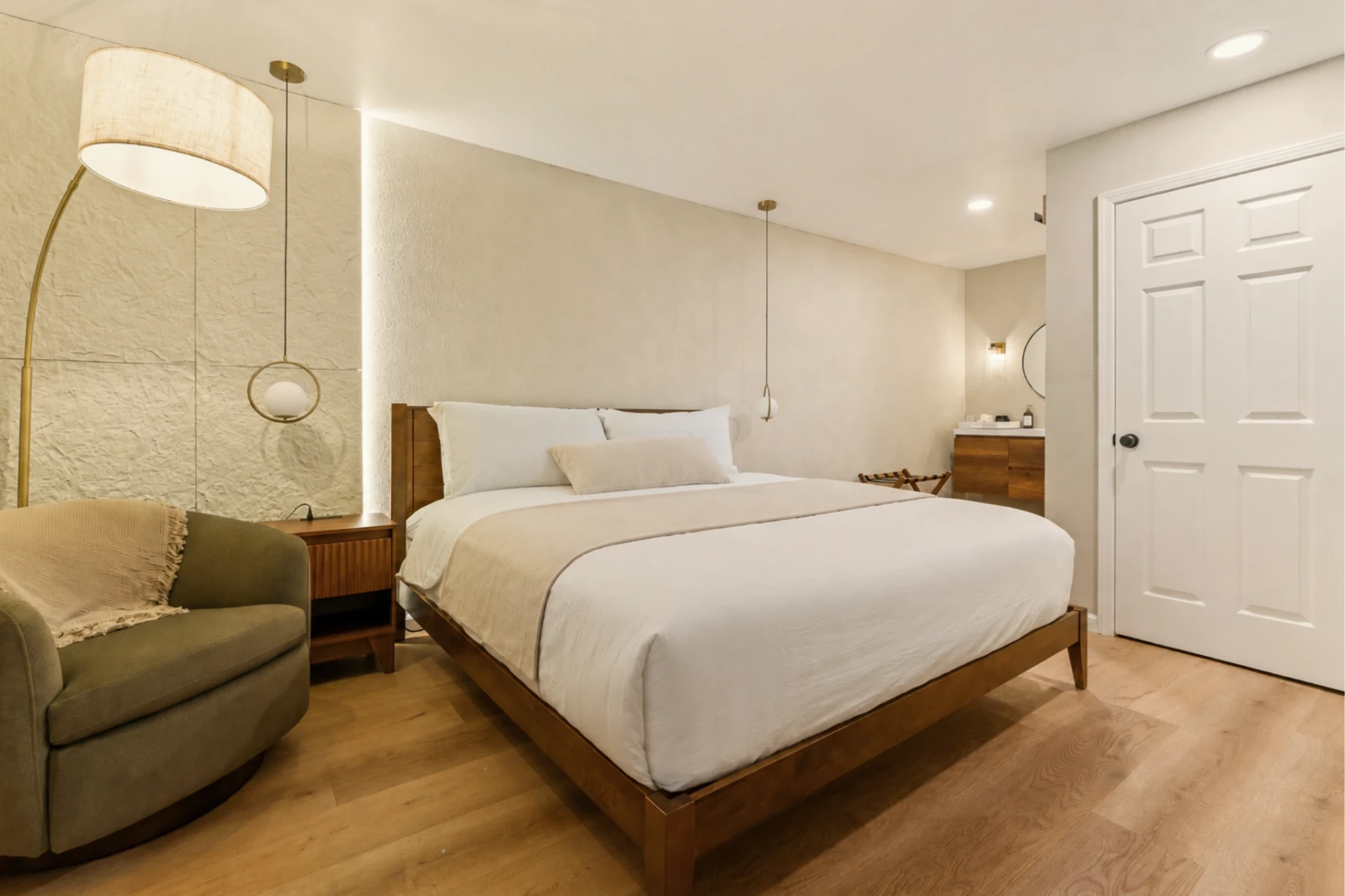 Suite with king bed, warm wood floors and soft lighting at Forest Springs Resort