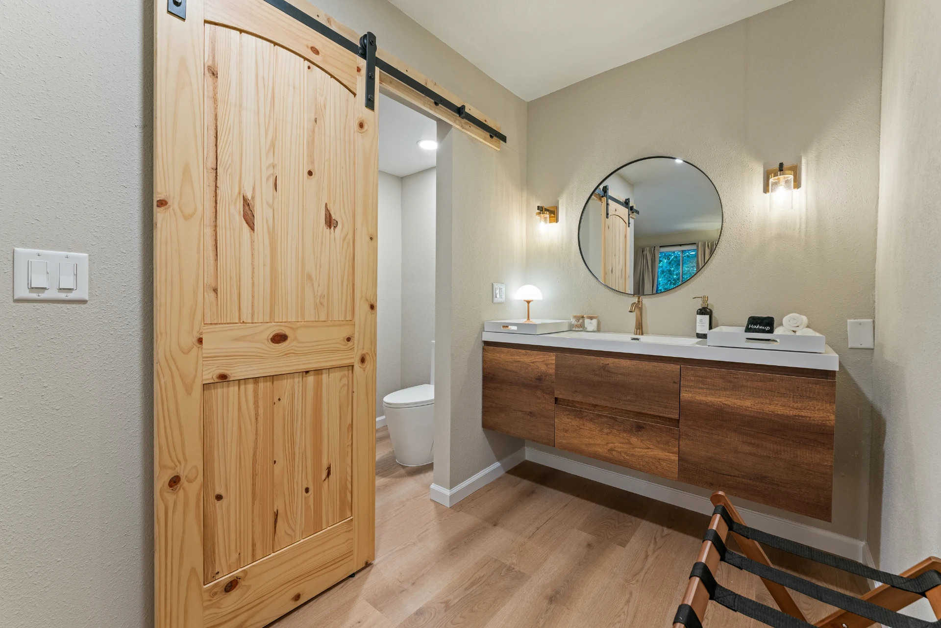 Suite vanity with round mirror and sliding barn door