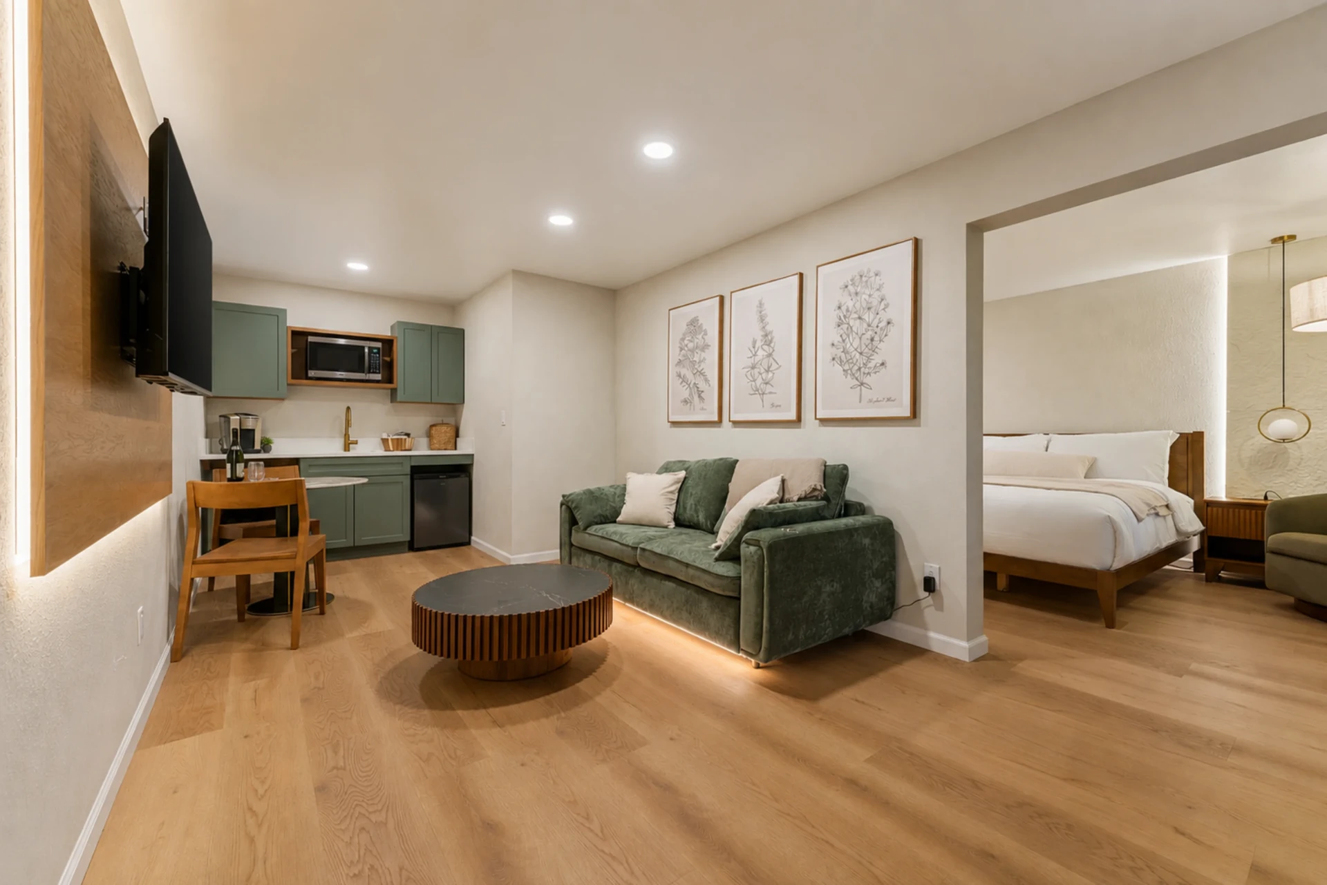 Suite living area with green sofa opening onto the bedroom