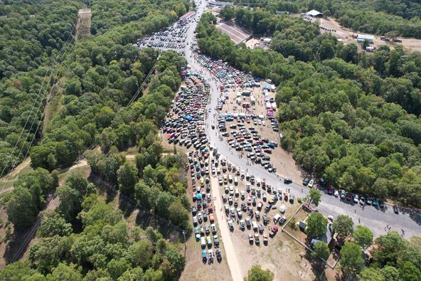 Aerial view of hundreds of Jeeps gathered in the wooded Eureka Springs event grounds